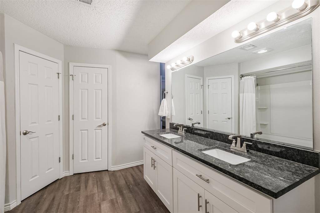 In the primary bathroom we have featured a double sink vanity, with plenty of cabinet storage, and just one o the walk-in closets on the far end.
