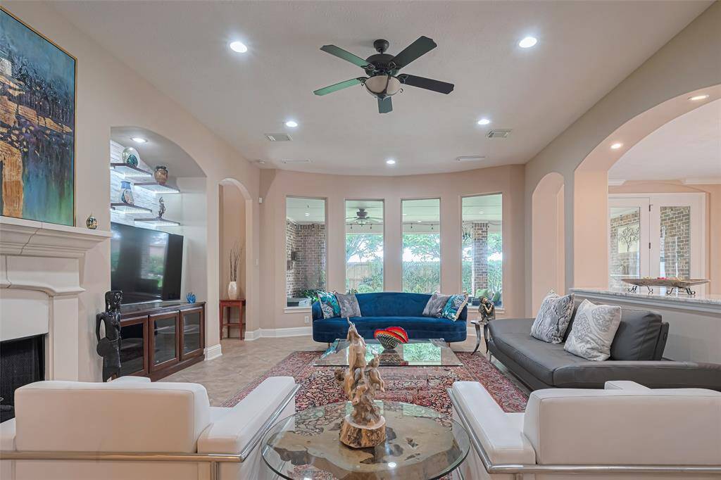 Warm and inviting, the expansive family room features a wall of tall windows overlooking the backyard, allowing for natural light to pour in