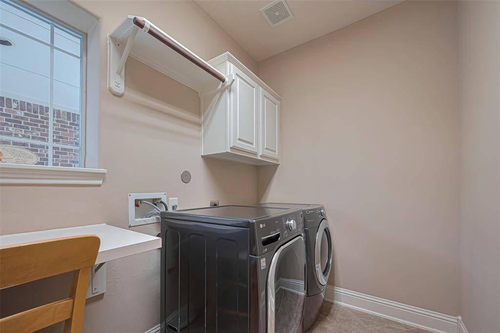 Functional laundry room with built-in cabinetry, hanging rod, and workspace—designed for practicality and ease of use
