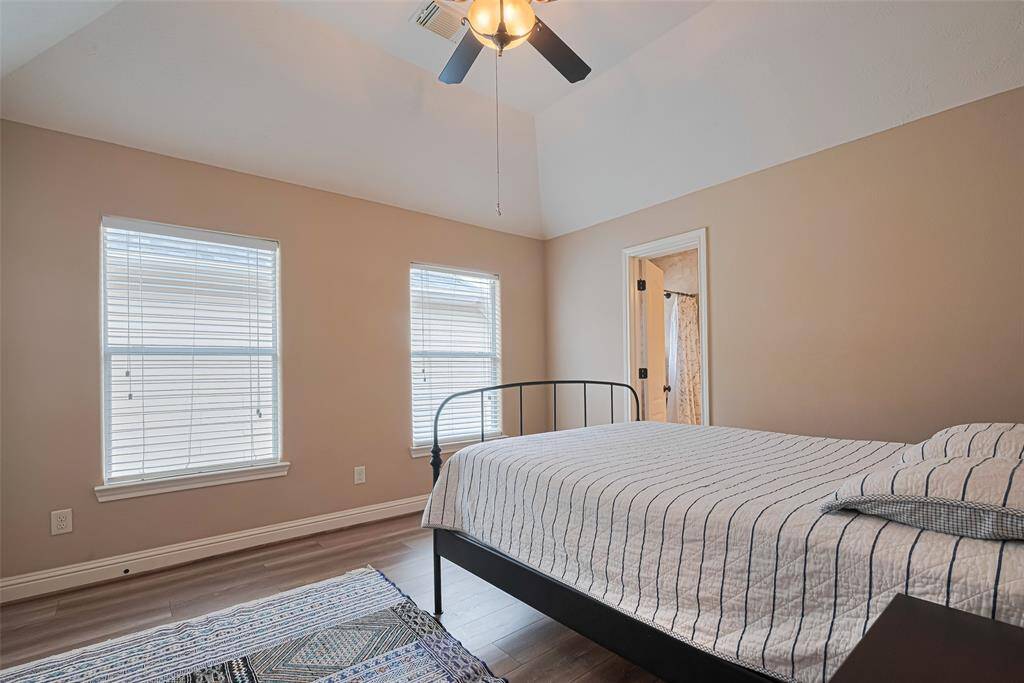 This comfortable and spacious bedroom features high vaulted ceilings, two large windows that let in an abundance of natural light, and easy access to a full en-suite bath