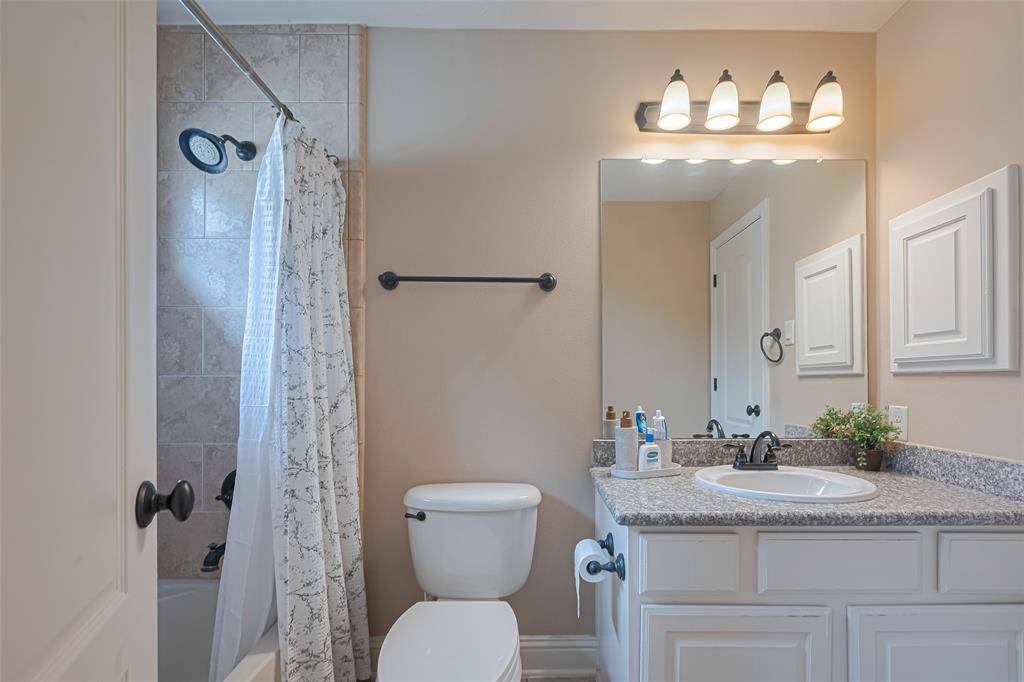 A large mirror and well-placed lighting add brightness, while the transom window above the shower brings in natural light without compromising privacy