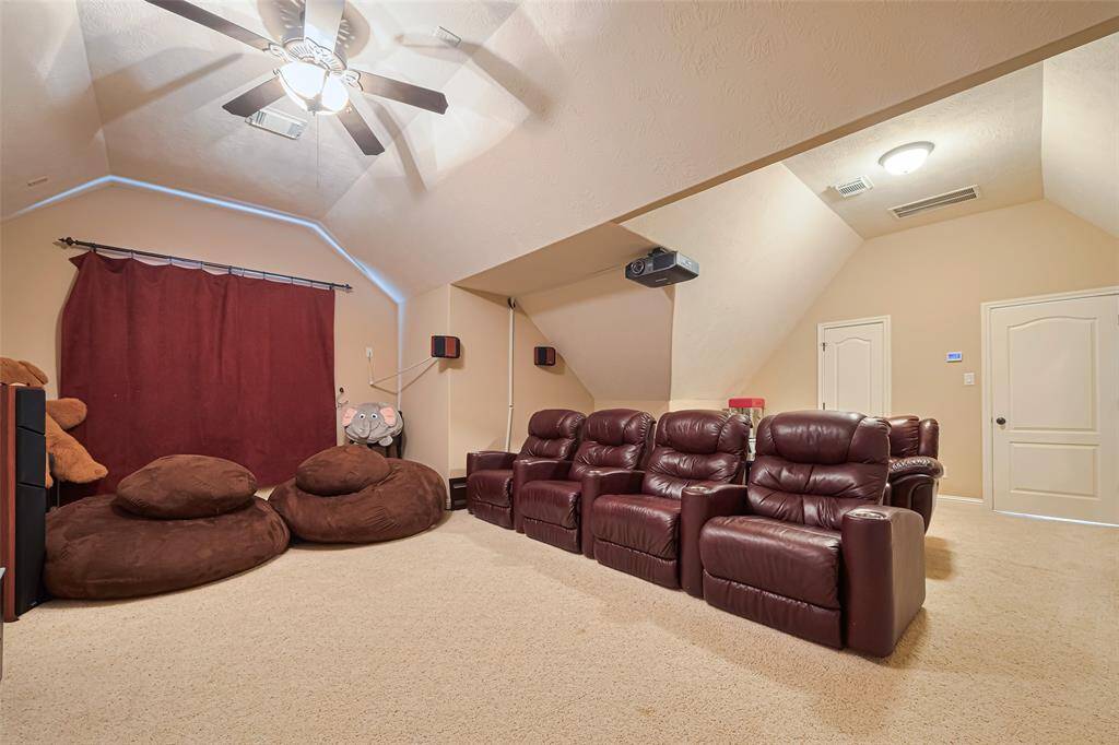The sloped ceilings and cozy carpeting enhance the theater ambiance, while ample space allows for popcorn machines and media storage to complete the experience