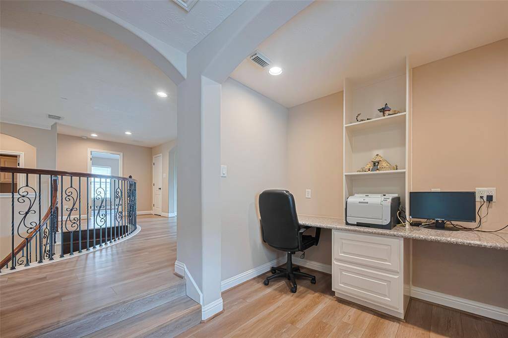 Nestled just off the curved staircase landing, this built-in workstation provides a quiet and functional space for remote work, studying, or managing daily tasks