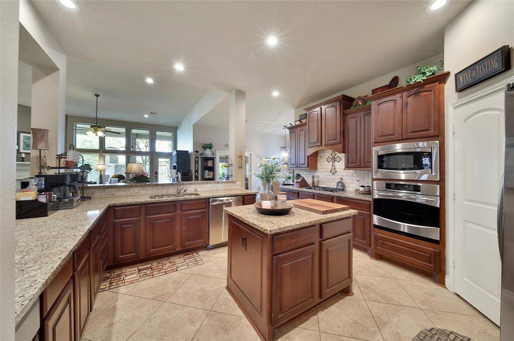 Island kitchen with breakfast bar and sleek stainless steel appliances.