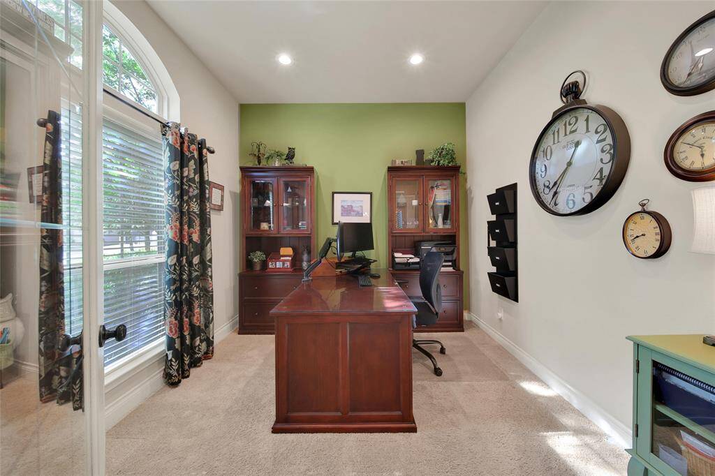 The home office is filled with bright natural light and glass pane doors to keep you connected to the entrance of the home.