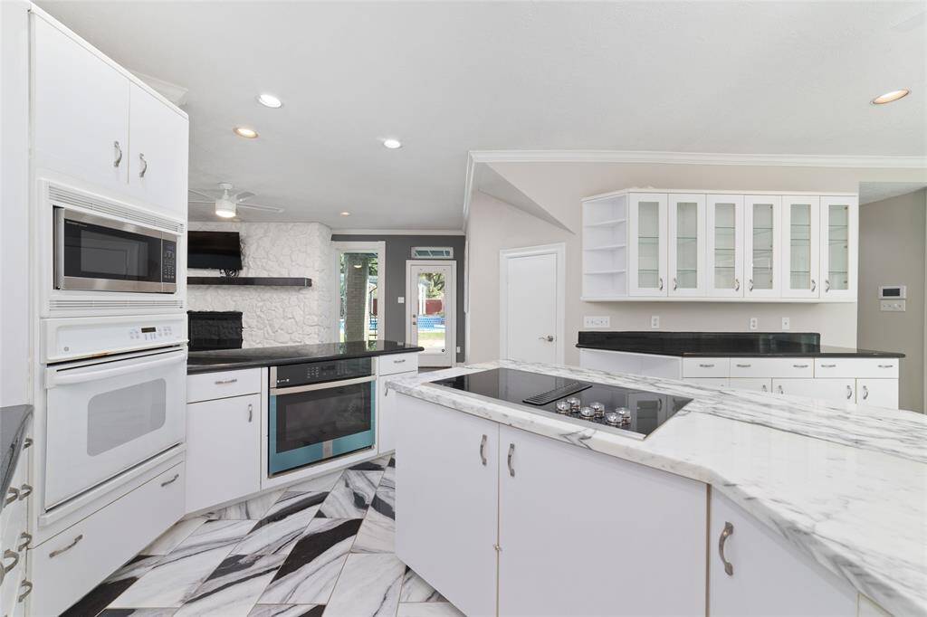A great view of the kitchen and how it looks into the downstairs living area and beautiful back yard.