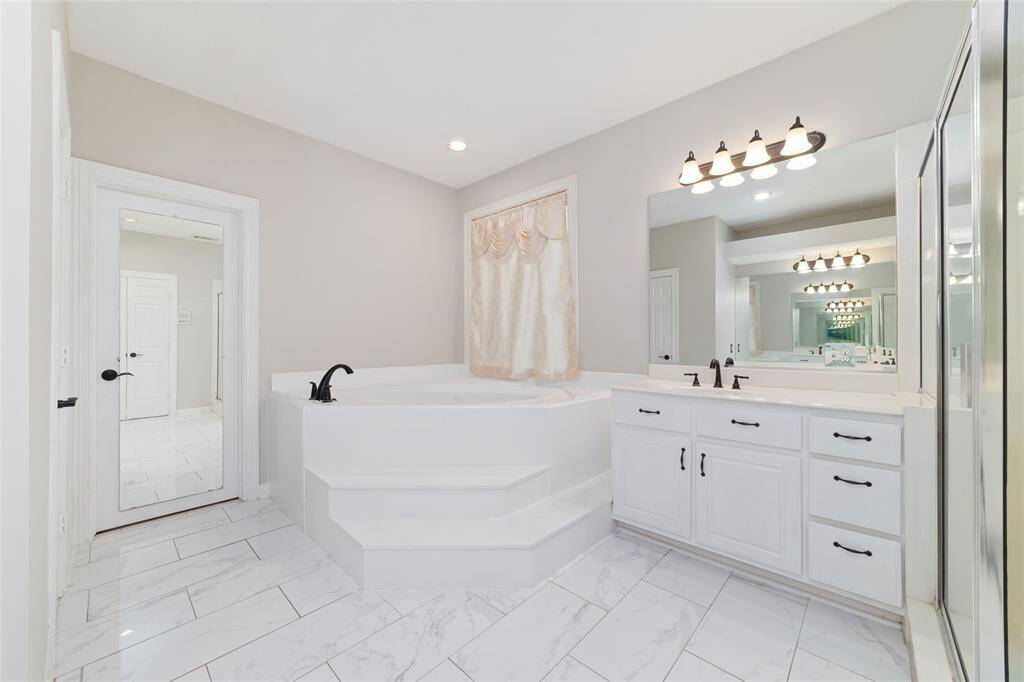 A view of the soaking tub, and a mirror on the closet door.