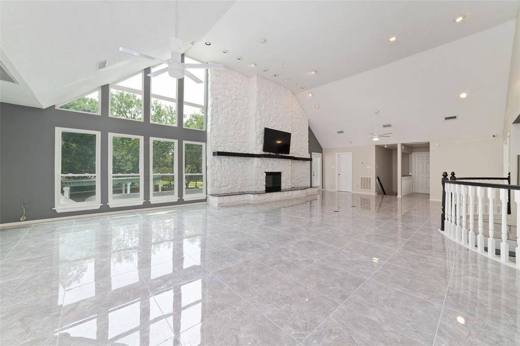 Up the beautiful dual staircases is a second large living area with a fire place (TV/Mount are included) with new tile flooring and amazing natural light.