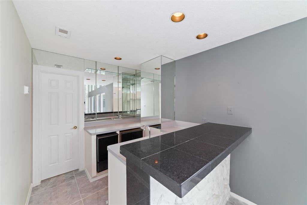 The upstairs wet bar with a refrigerator, ice machine and sink.  The door leads to a closet with cameras.  Great for upstairs entertaining.