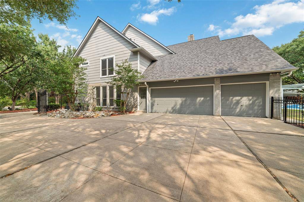 Three car garage with a side entrance/exit and an oversized driveway.  Includes a basketball net.