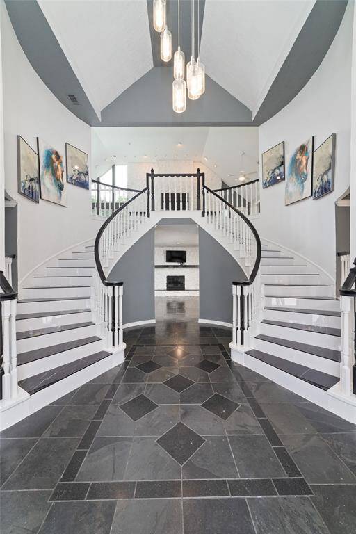 A grand entrance with beautiful tile and a chandelier.