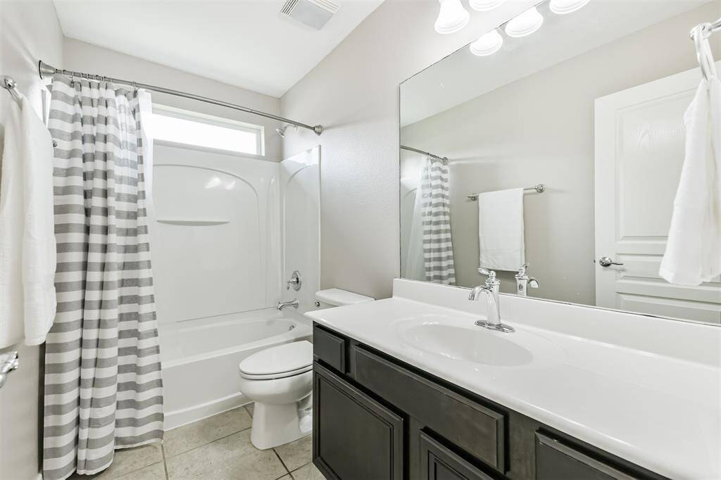 Another full-sized bathroom is upstairs with a large vanity and a tub-shower combo.