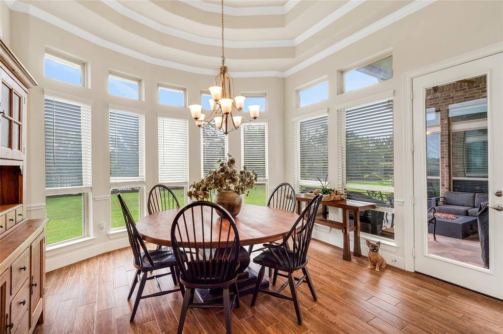 This eye-catching dining room with its dazzling tray ceiling and numerous windows that overlook the serene backyard and lake is a one of a kind space you will love.
