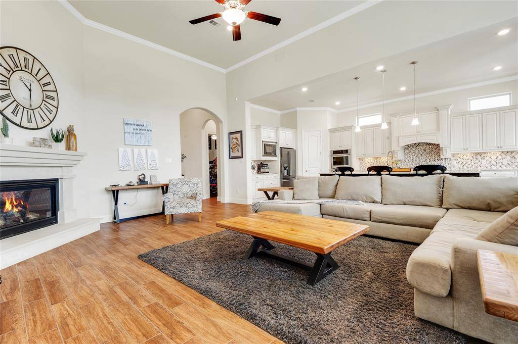 You will love this open floor plan concept including this centrally located family room with its gas log fireplace, custom wall unit, and wall of windows overlooking the backyard and lake.