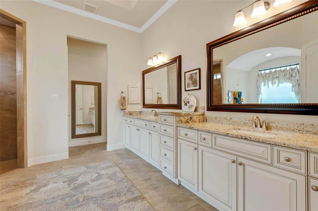 Primary bathroom has a walk in tiled shower, dramatic soaking tub, and this extra long vanity with two sinks of course.