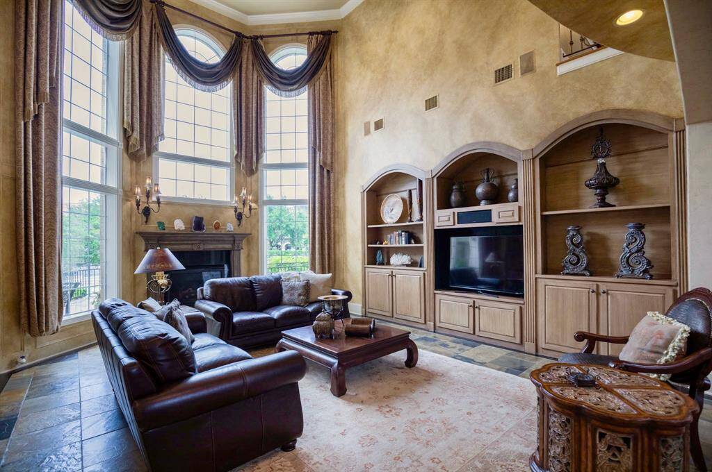THE STUNNING 2 STORY FAMILY ROOM IS ENHANCED BY SOARING CEILINGS, FLOOR TO CEILING WINDOWS, AND CUSTOM BUILTINS!