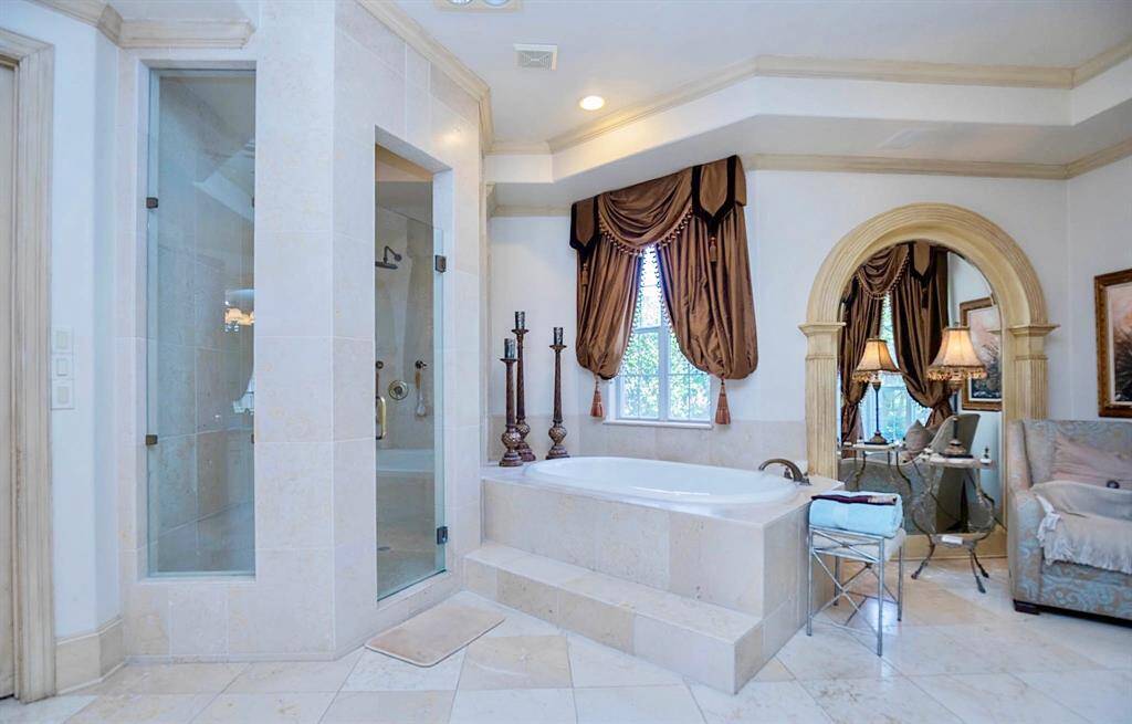 THE PRIMARY BATH IS COMPLETE WITH OVERSIZED SOAKING TUB, FRAMELESS GLASS SHOWER, AND A SITTING AREA TO RELAX IN!