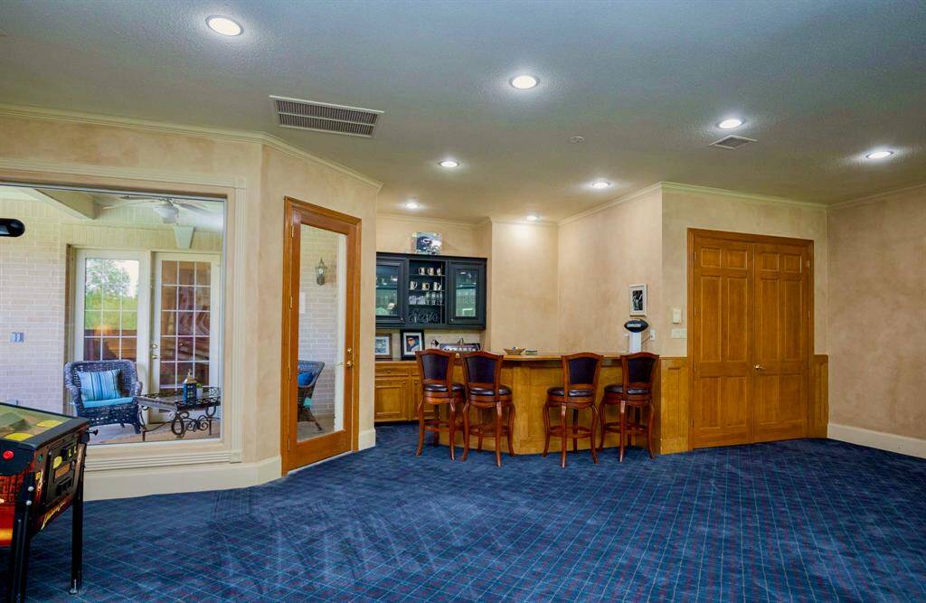 THE GAME ROOM FEATURES A FULL SIZED WET BAR WITH A DOOR LEADING TO A COVERED PATIO!