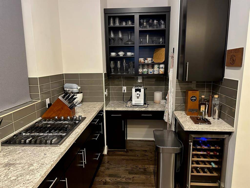 Wine fridge and gas stovetop in kitchen