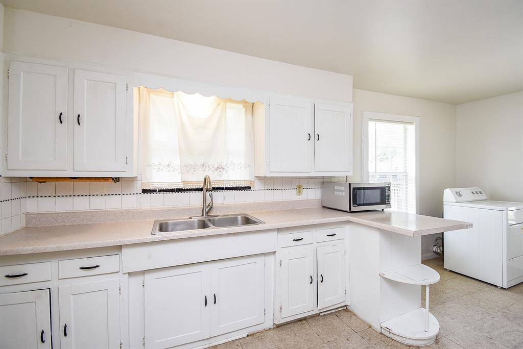 Kitchen has laminate countertops and linoleum flooring.