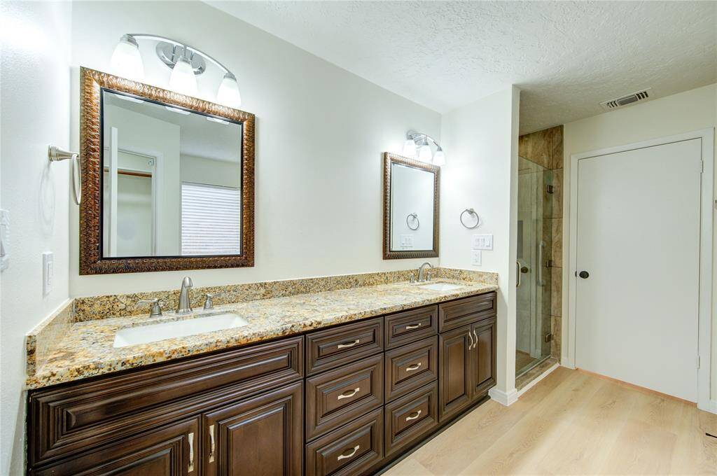Frameless glass walk-in shower on right.