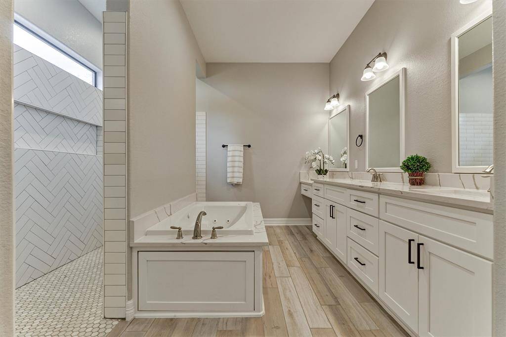 Every expected amenity in this luxurious bathroom with a soaking tub, dual sinks, vanity area, and extra-large, walk-in shower!