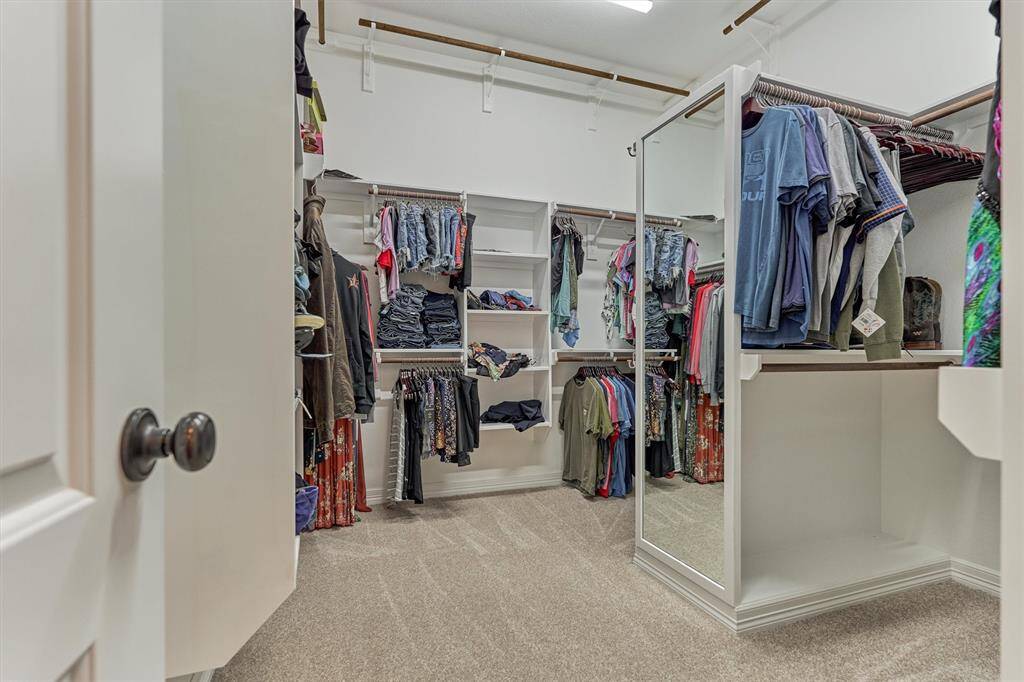 This massive walk-in closet is optimally designed with a dressing area and an abundance of shelving!