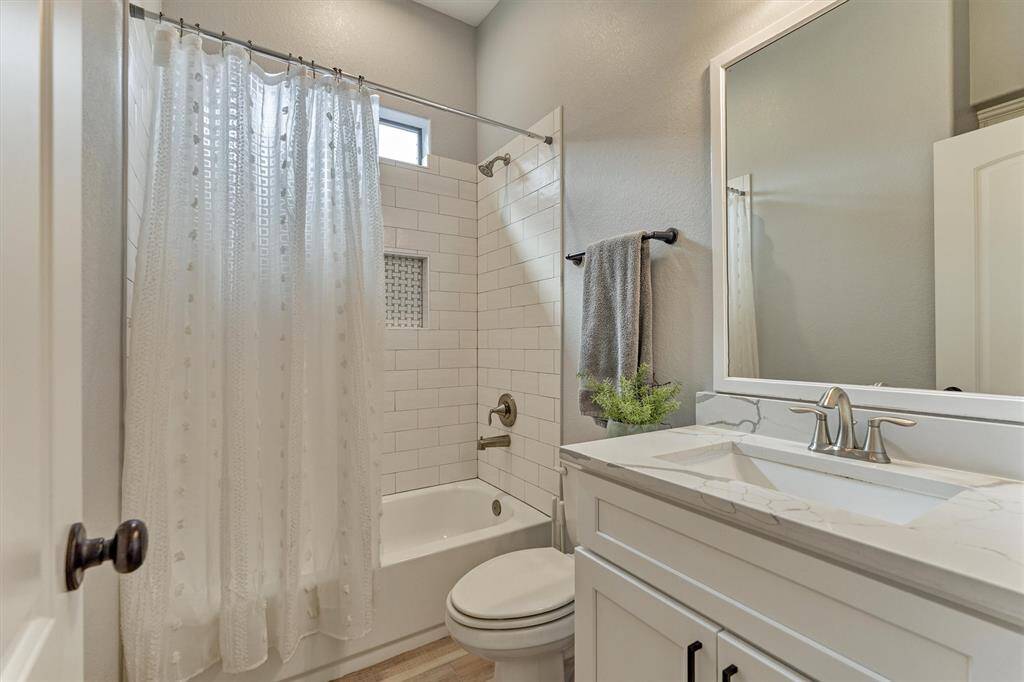 Full secondary bathroom with beautiful tilework in the tub/shower and quartz countertops!