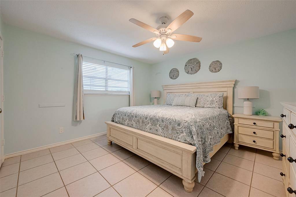 A generous layout with a large window and ceiling fan ensures comfort and versatility in the primary bedroom.