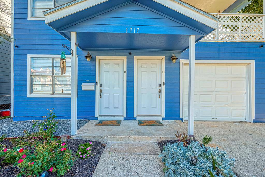 This duplex features a separate upstairs a unit, with its own charming white entry door tucked beneath a covered porch.
