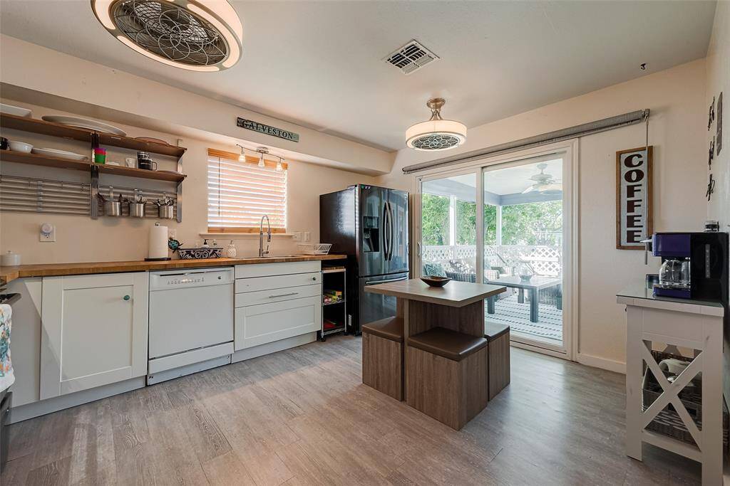 Awash in natural light from sliding doors, windows, and stylish semi-flush mount lighting, this kitchen space blends practicality with warmth.