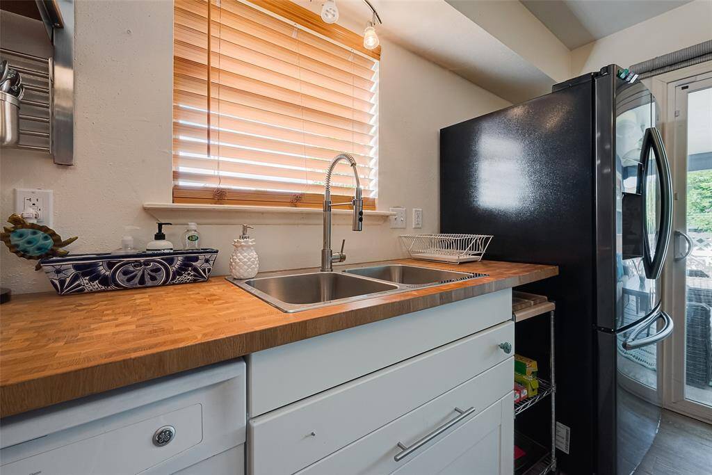 A closer view of the sleek butcher block countertop, dual sinks, and smooth cabinetry—each element thoughtfully chosen for both style and function.