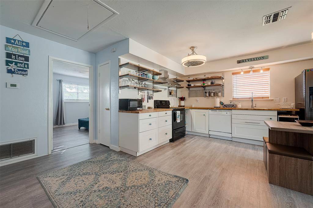 The same durable vinyl plank flooring extends throughout, leading toward a nearby bedroom, ensuring a cohesive and inviting aesthetic.