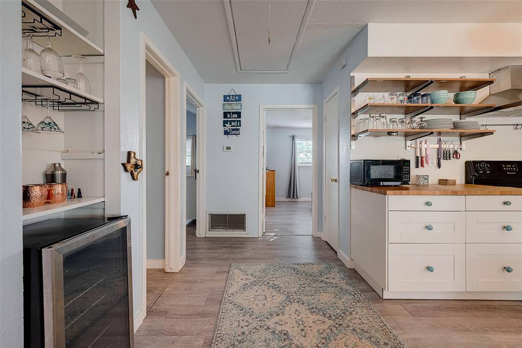 A glimpse down the hallway reveals access to the bedrooms, emphasizing the well-organized layout.
