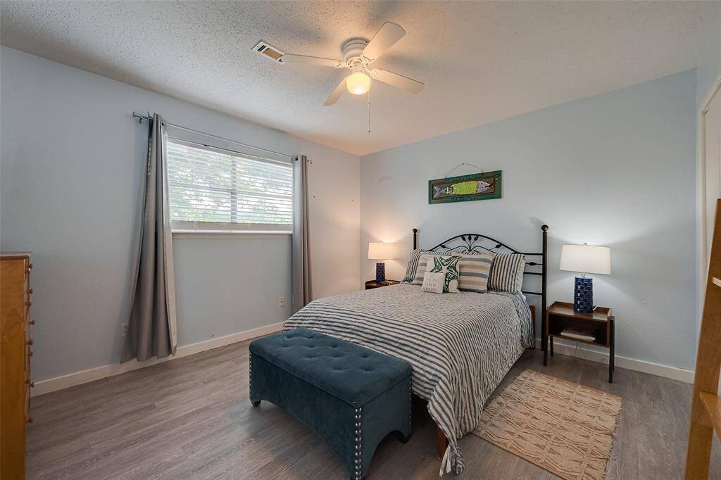 This bedroom is a bright, airy space with a large window and ceiling fan, offering comfort and flexibility.