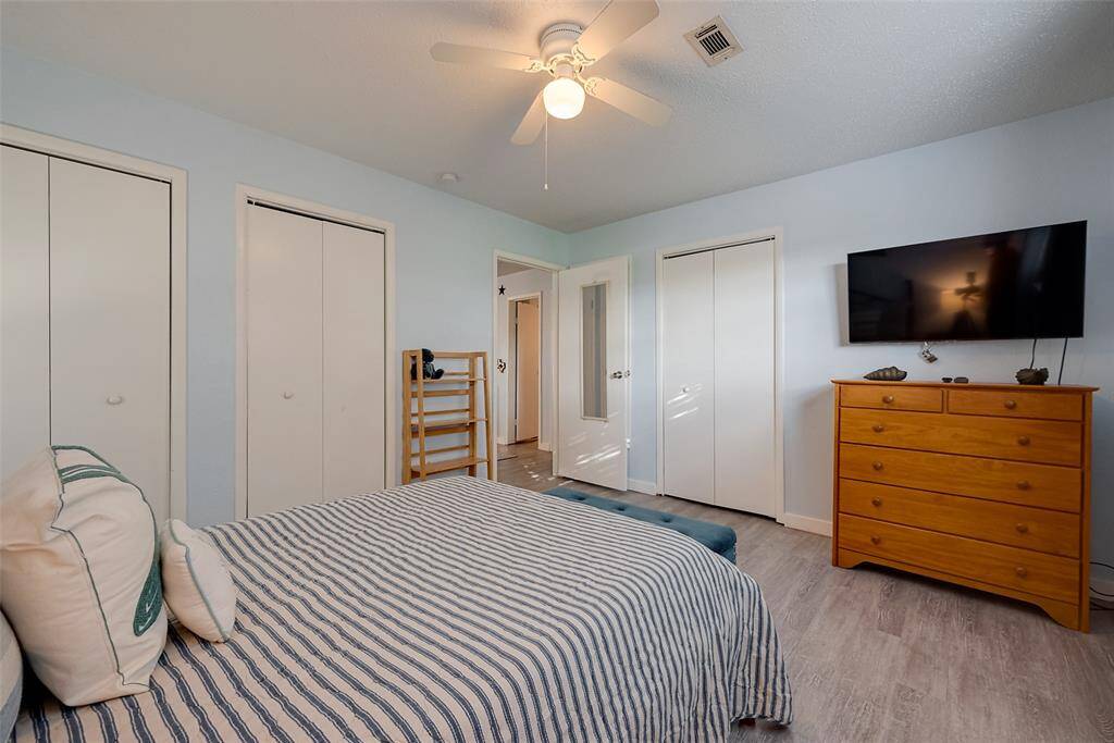 A neatly designed closet and a glass-paneled white door add a charming touch while maintaining a light and airy feel.