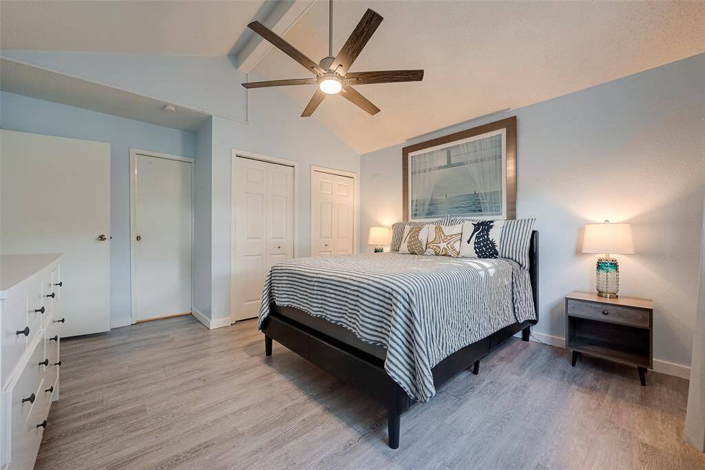 This well-sized bedroom also features soft pastel blue walls that enhance the light, airy ambiance. The neutral vinyl flooring ties the space together, creating a soothing retreat.