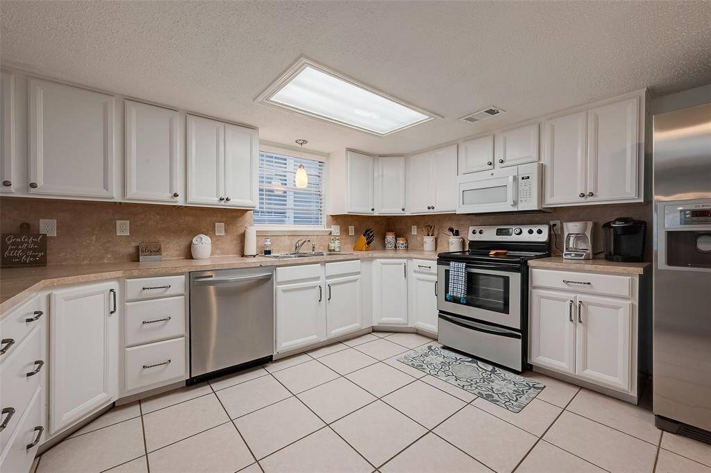 This well-appointed kitchen offers abundant storage with matching upper and lower cabinetry, ensuring both style and practicality.