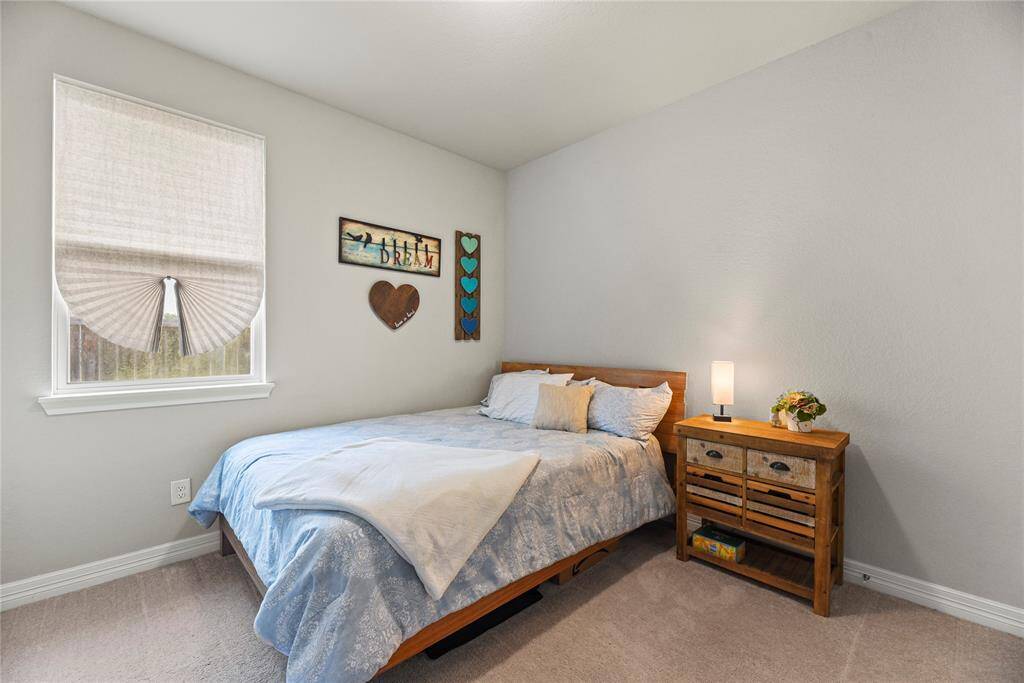 Enter the third guest bedroom with tall ceilings, a walk-in closet and neutral tones in the paint and carpet.
