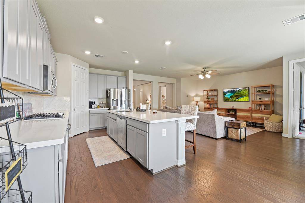 Many memories will be created by spending time with family and friends in this inviting kitchen and family room combination.