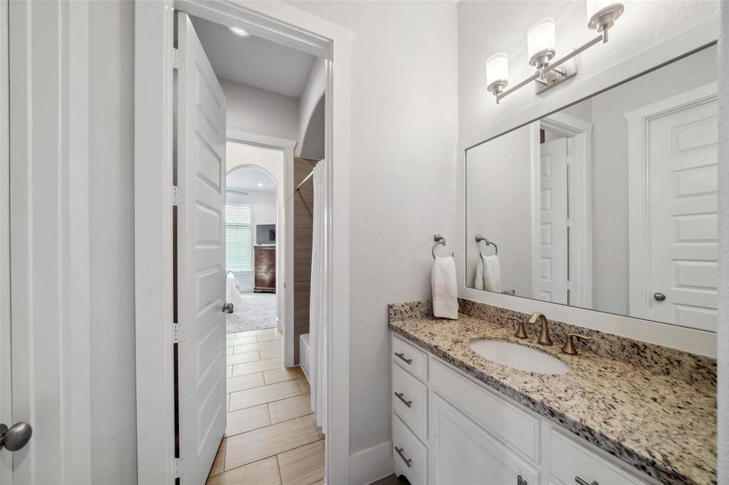 Here is the other side of the Hollywood bath, showcasing granite countertops, designer hardware, and stylish fixtures, combining elegance with functionality.