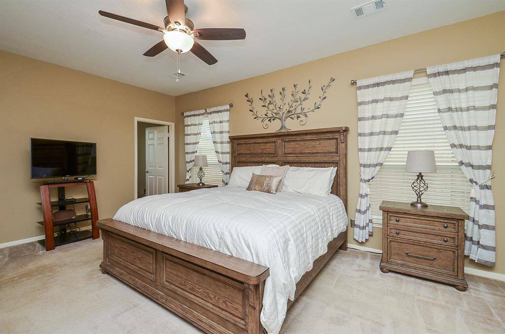 This spacious premier bedroom is well-lit with two windows creating a cozy and inviting atmosphere.