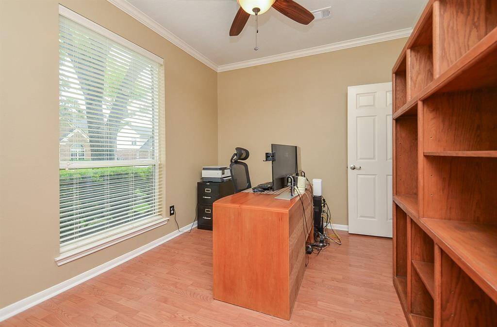 This room is a well-lit ideal home office space with a large window.