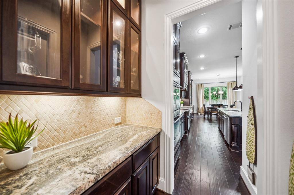 This elegant butler's pantry connects the formal dining room and kitchen, conveniently located opposite the walk-in pantry.