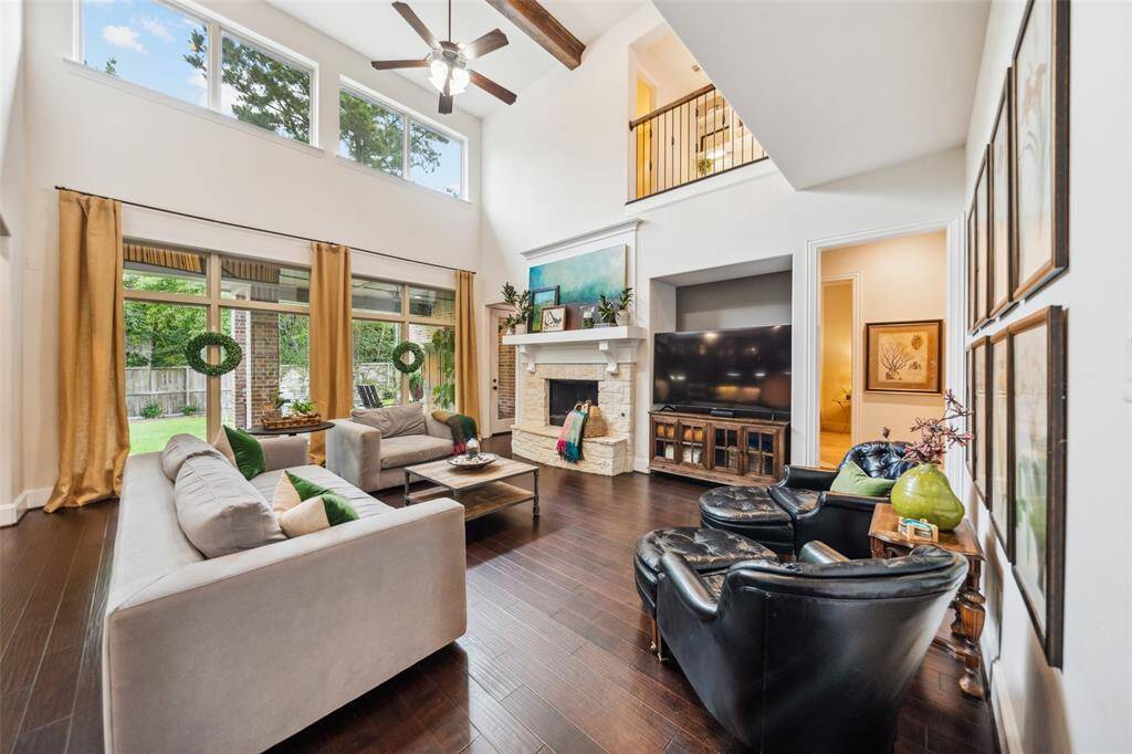 Spacious family room with stunning wood-beamed ceilings, expansive windows, and a cozy gas fireplace.