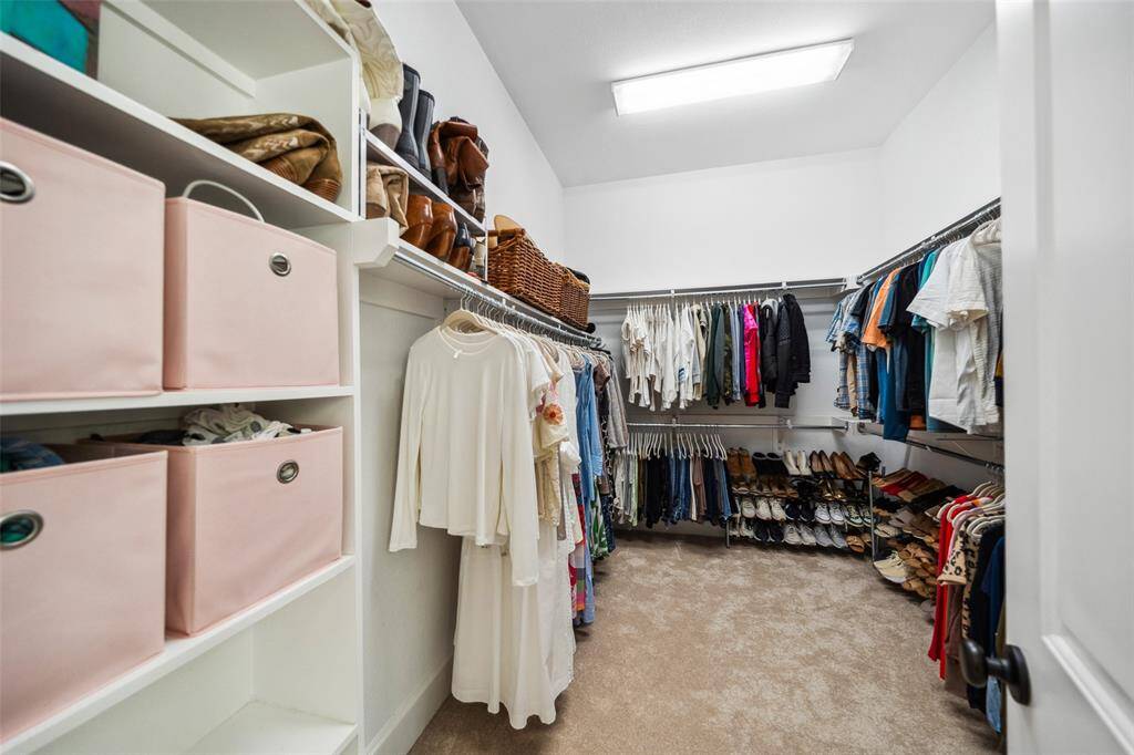 Large Primary walk-in closet features lots of additional storage space.