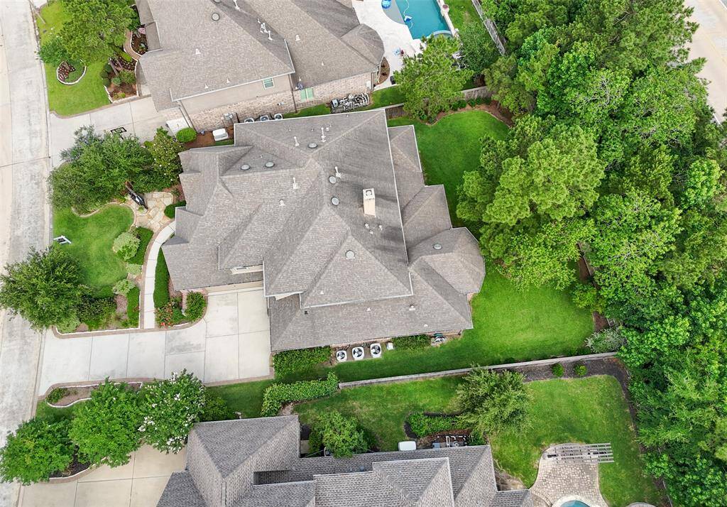 Aerial shows the ample parking and lush landscaping of the front garden area.