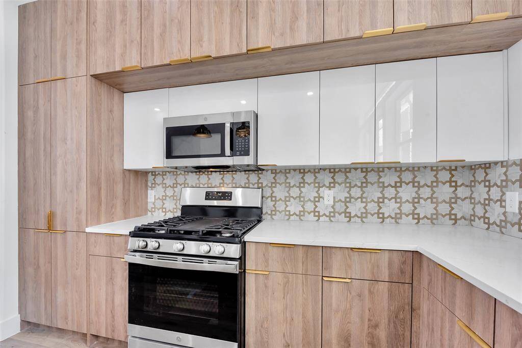 The dual toned modern cabinets offer plenty of storage and lend beautiful custom detail to the home. The stainless steel gas range and microwave make cooking a joy.