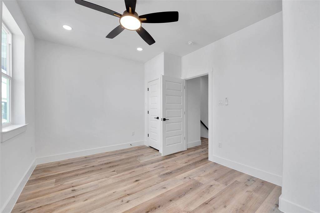 The window on the left brings in lots of natural light in the third bedroom. Beautiful floors throughout the home are easy to clean.