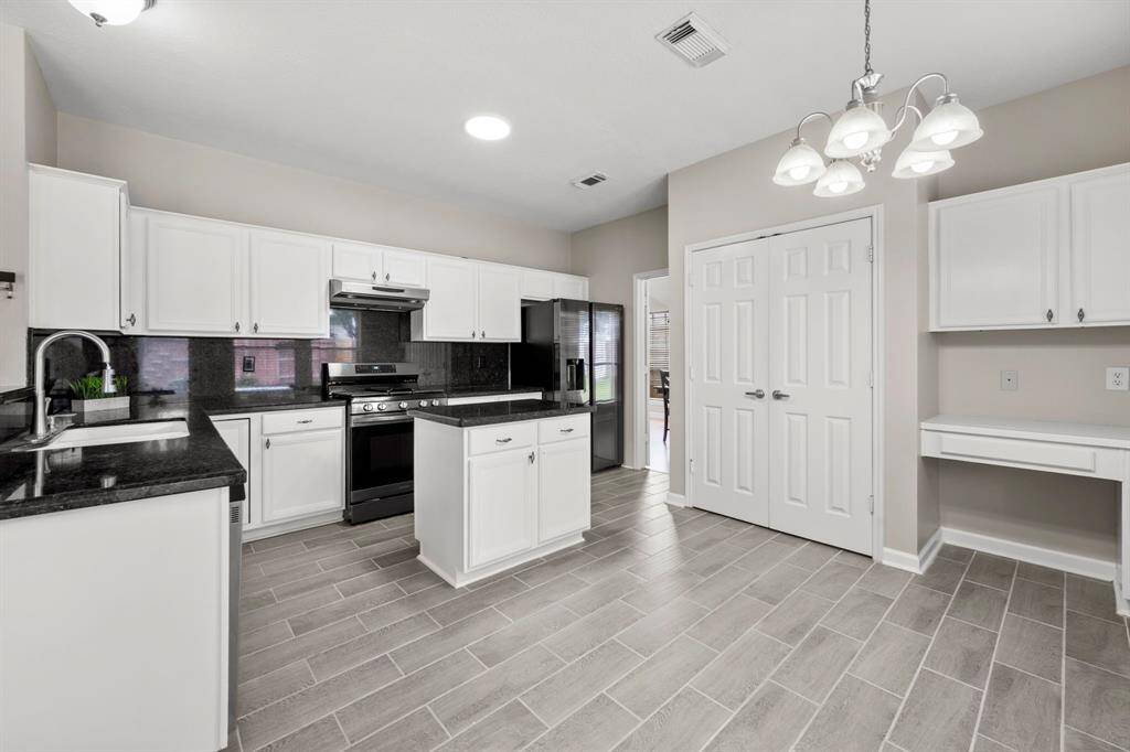 stainless steel appliances, granite countertops, wood cabinets, kitchen island, so much room for prepping meals and for family and friends to share countless moments.